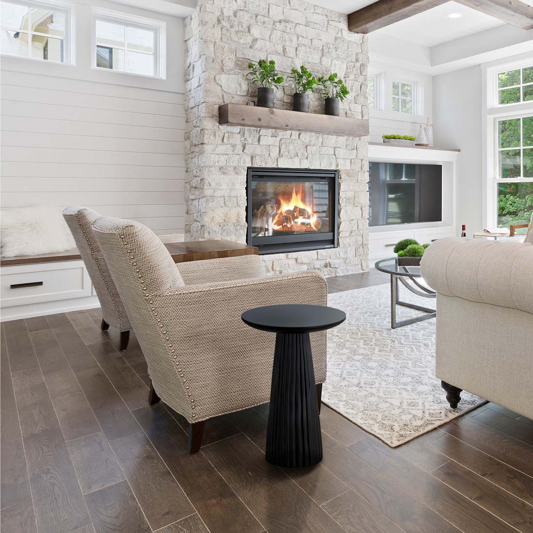 Load video: video showing a ribbed black wood finish in a living room that has a fireplace, two cream armchairs, light grey walls